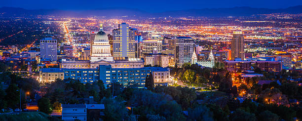 Salt Lake City downtown landmarks illuminated dusk panorama Utah USA Blue dusk skies over the city lights and landmarks of Salt Lake City, the monument spotlit dome of the State Capitol and the ornamental spires of the Mormon Temple surrounded by the skyscrapers of downtown, Utah, USA. ProPhoto RGB profile for maximum color fidelity and gamut. salt lake stock pictures, royalty-free photos & images