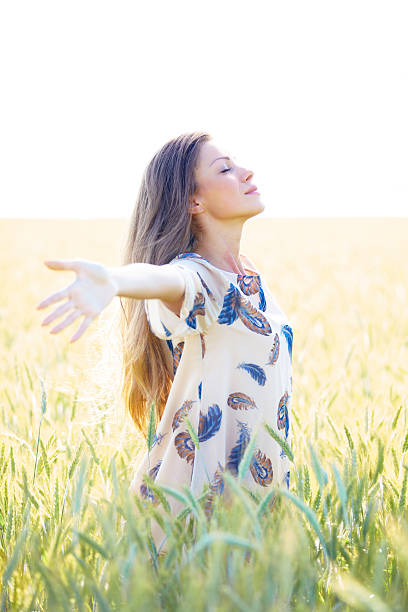 istock Woman with arms outstretched in wheat field 495558358