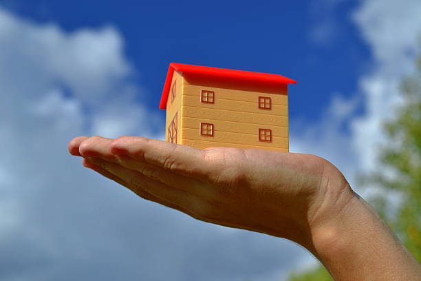 istock Toy house on palm 495558722