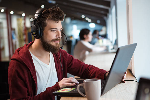 istock Concentrated male using headset and laptop 495561624