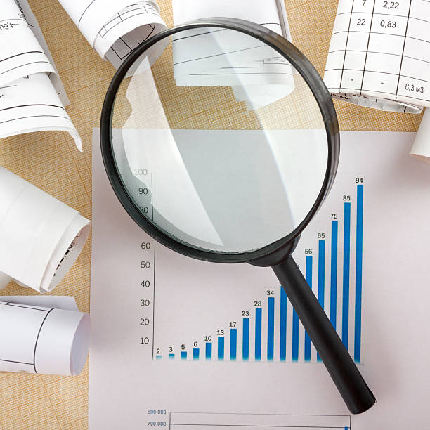 istock Architectural blueprints, blueprint rolls magnifying glass on wooden background. 495561916