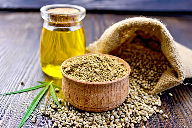 istock Flour hemp in bowl with grain and oil on board 495562954
