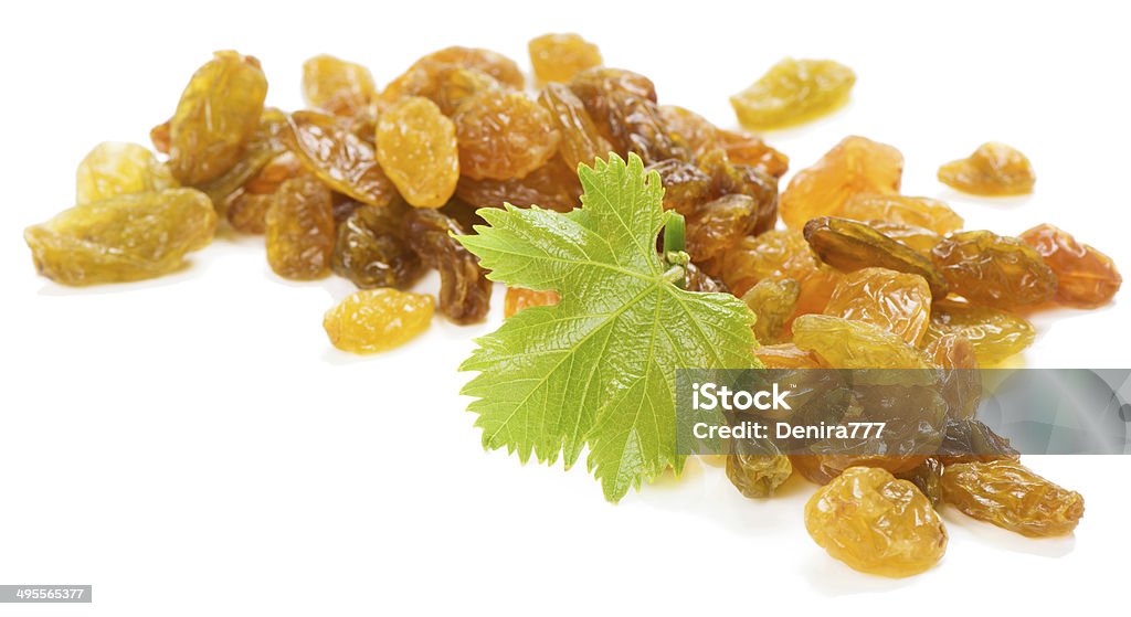 Golden raisins Yellow raisins with green leaf of grape isolated on a white background Berry Fruit Stock Photo