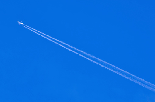 Airplane leaving traces or chemtrails is flying in the sky