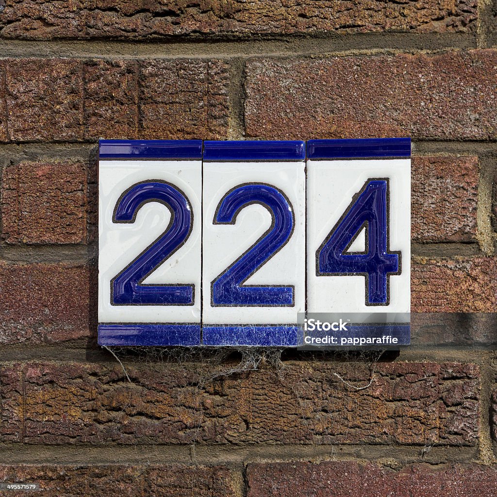Number 224 ceramic house number two hundred and twenty four, on three separate tiles. Blue Stock Photo