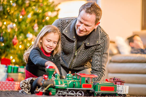istock Father and Daughter Playing Together with Christmas Train 495573468