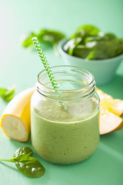 istock healthy green spinach smoothie with mango banana in glass jar 495574132
