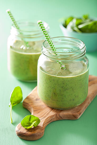 istock healthy green spinach smoothie with mango banana in glass jar 495574166