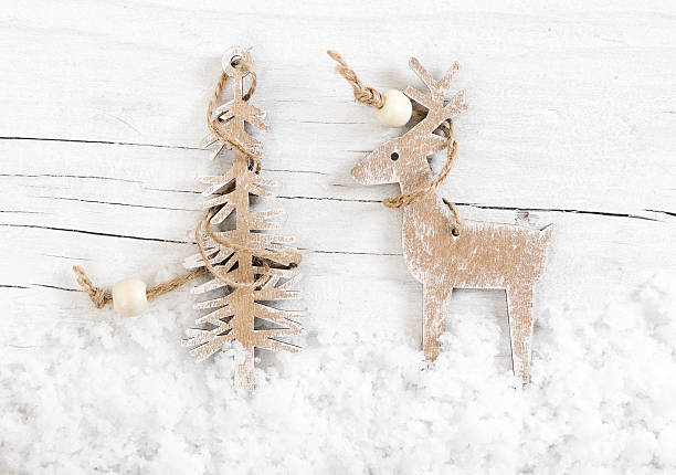 istock Decorative wooden deer and tree on snow wooden background. 495574784