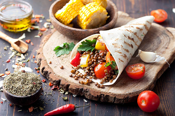 istock Vegan tortilla wrap, roll with grilled vegetabes, lentil, corn cob. 495575016