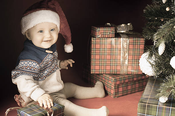 istock Happy baby with many gift box near decorated Christmas tree 495577566