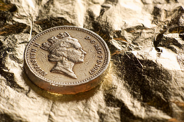 London, England - May 27, 2005: A British one pound coin with the face of Queen Elizabeth II, embedded in gold leaf.