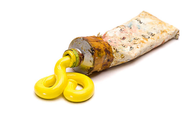 A used tube of yellow artists oil paint.