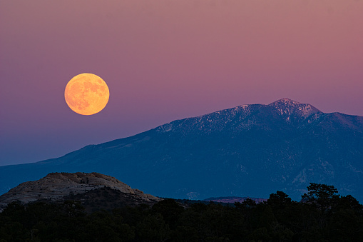 Full Moon Rising Over Desert and Mountains - Scenic landscape with sunset colors in Southwest Utah USA.