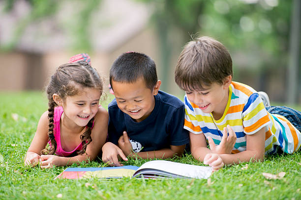 istock Children Reading a Book at the Park 495579640
