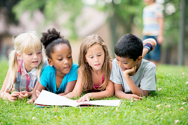 regarde une photo livre dans le parc - summer recreation photos et images de collection