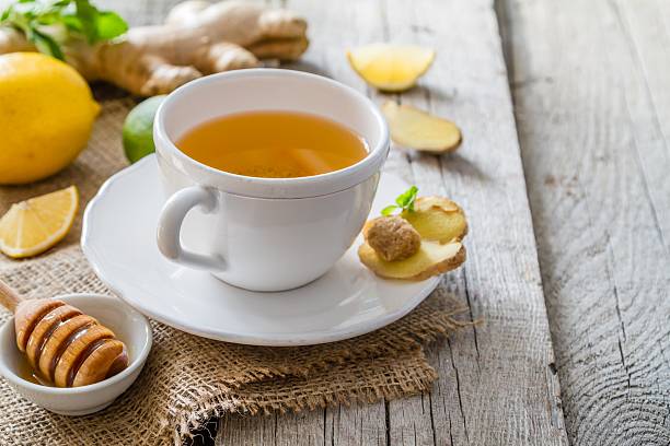 Ginger tea and ingredients on rustic wood background stock photo
