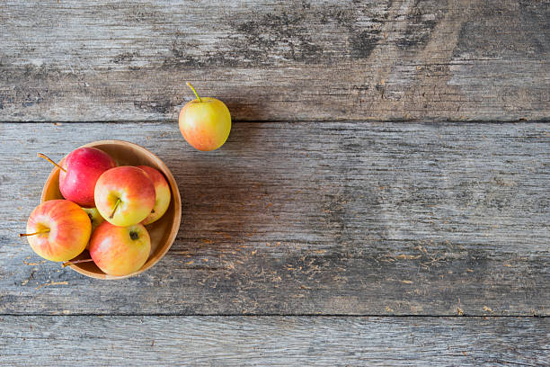 istock Apples in a wood bowl on wooden background. 495581184