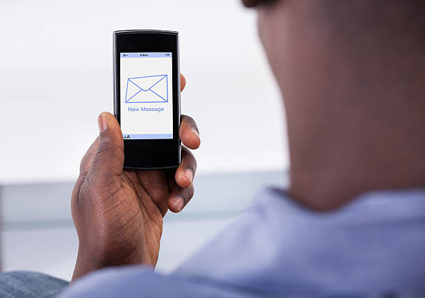 Close-up Of Person Holding Mobile Phone With One New Message Showing On A Screen