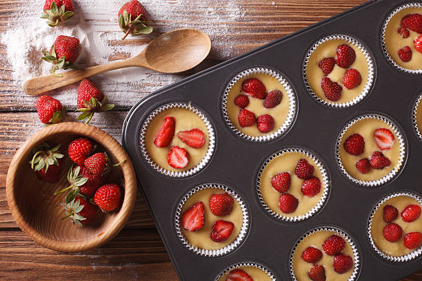 istock cooking muffins with fresh strawberries horizontal top view 495588760