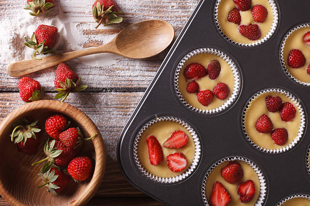 istock Preparation of muffins with fresh strawberries horizontal top vi 495589134
