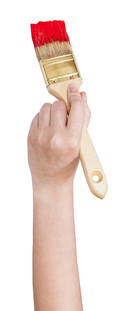 painter hand with flat paint brush paints in red