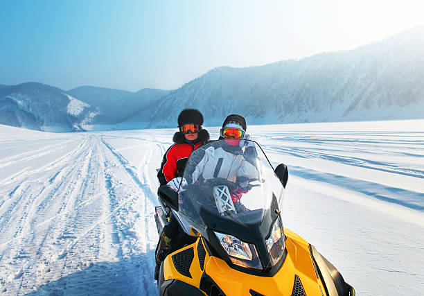 istock Man and woman riding on snowmobile 495589962