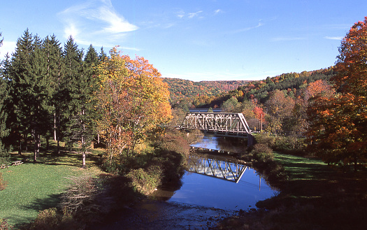 Reflection of old bridge in Casselman River and autumn colors  along US Highway 40 near Grantsville Maryland