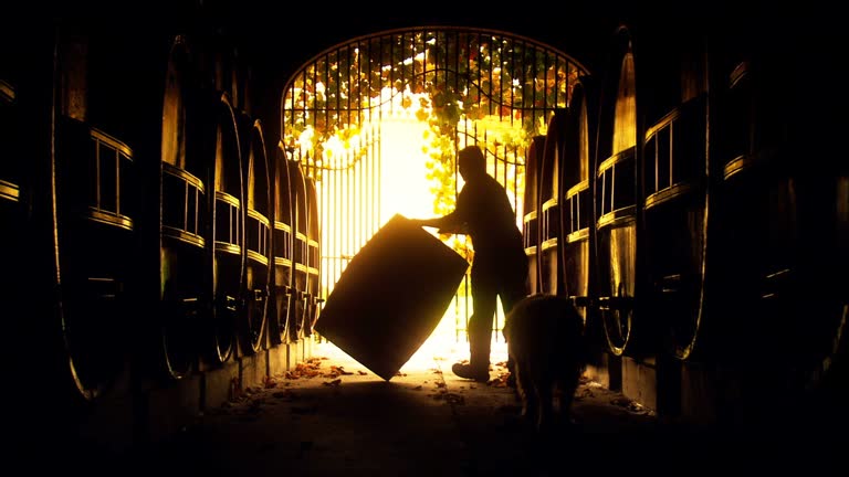 Abstract of vigneron winemaker rolling vintage wine barrel