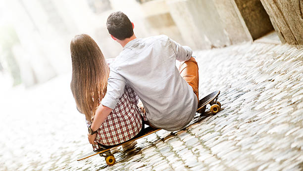 istock Young couple sitting on longboard 495600368
