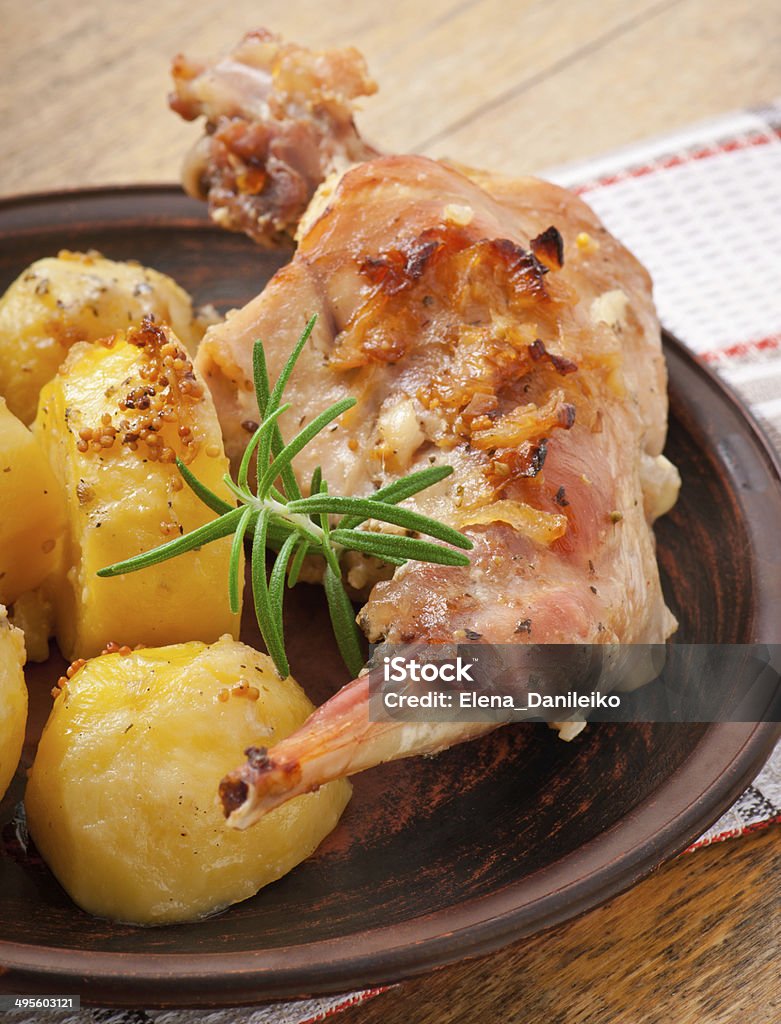 Oven Baked rabbit legs with potatoes and rosemary Animal Body Part Stock Photo