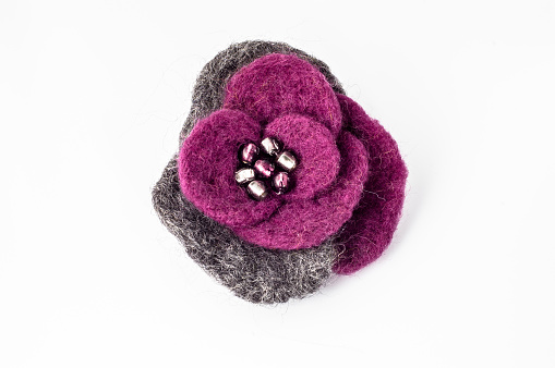 Felt brooch. Handmade stylish felt jewelry made with gray and violet felt isolated on a white background.