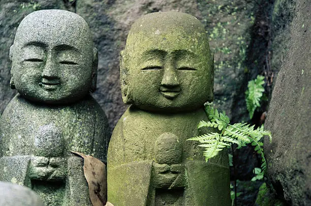 small sculptures of Jizo deities in Japanese forest