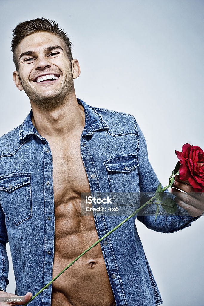 Alegre Musculoso homem segurando rosas - Foto de stock de 20 Anos royalty-free