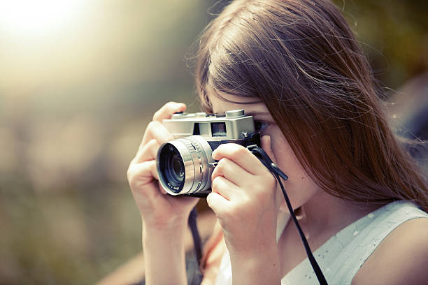 istock Young Girl Taking Photo With Vintage Camera 495606007
