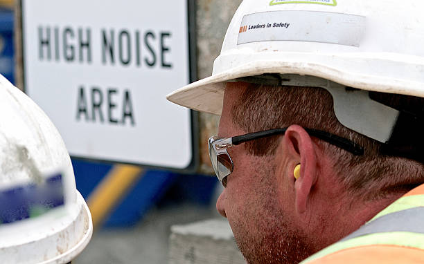 Construction Worker Hearing Protection Construction Worker wearing personal protective hearing protection in a high noise area. ear protectors stock pictures, royalty-free photos & images