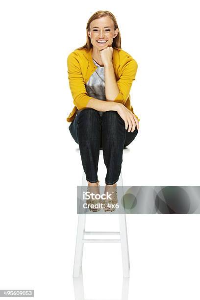 Happy Young Woman Sitting On Stool Stock Photo - Download Image Now - Stool, Sitting, Women