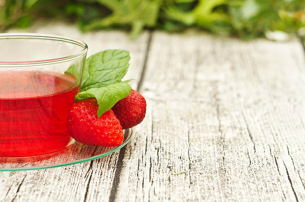 istock cup of tea with strawberries on wooden table 495610589