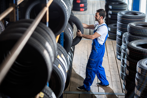 Auto mechanic  choose tire for car at a tire store