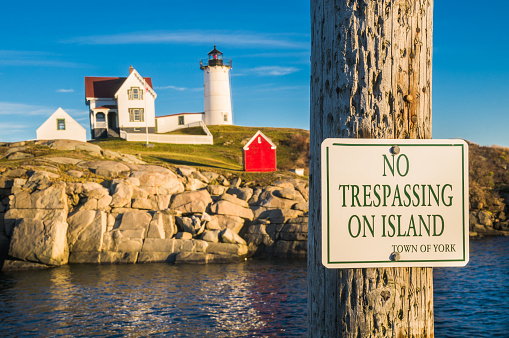 A No Trespassing sign at Cape Neddick light in York,  Maine. Focus on sign.