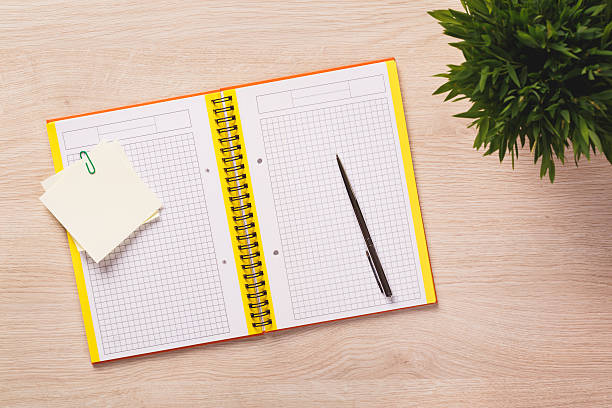 istock Top of desk with open notebook, pen, notes. 495622640