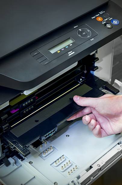 istock Man hand puts toner in the printer 495623886