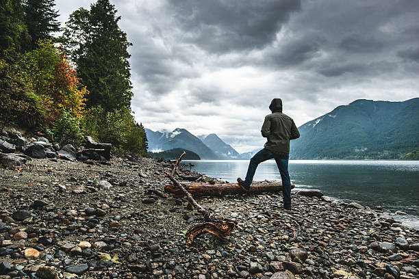 Solitude man pensive on the lake side Solitude man pensive on the lake side spirituality adventure searching tranquil scene stock pictures, royalty-free photos & images