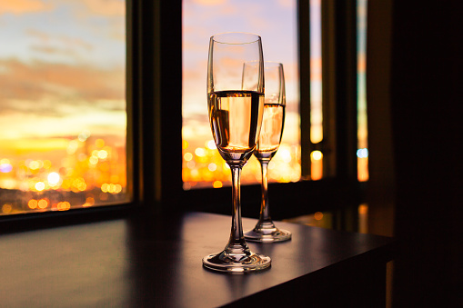 Couple of champagne glasses with a city view.