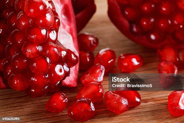 Ripe Pomegranate Seeds Closeup On A Cutting Wooden Board Stock Photo - Download Image Now