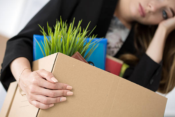 istock Young dismissed female worker in office holding carton box with 495625514