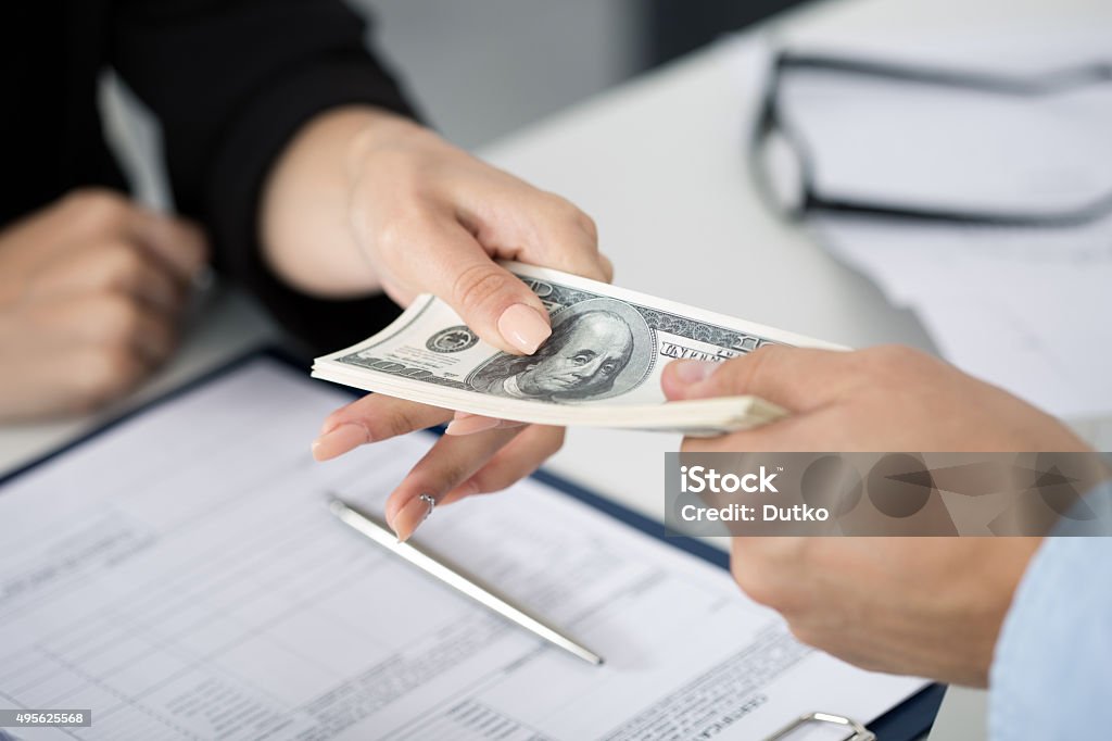 Woman taking batch of hundred dollar bills Woman taking batch of hundred dollar bills. Hands close up Currency Stock Photo