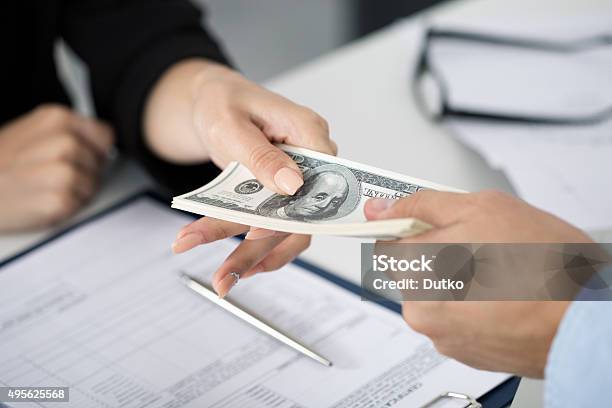 Woman Taking Batch Of Hundred Dollar Bills Stock Photo - Download Image Now - Currency, Financial Loan, Wages