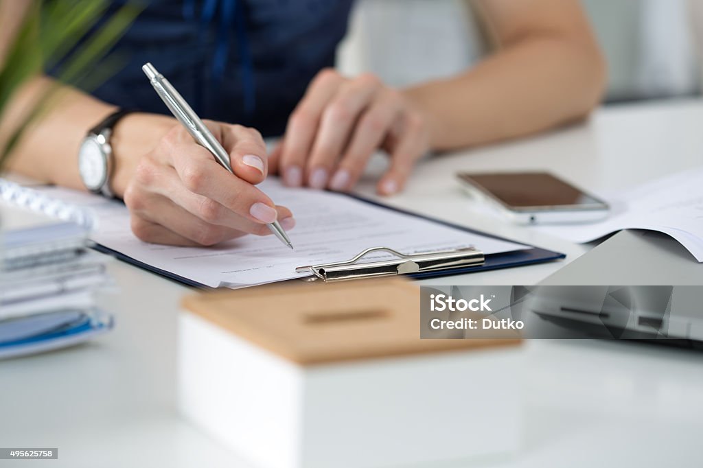 Woman writing something  sitting at her office Close-up of female hands. Woman writing something  sitting at her office Document Stock Photo