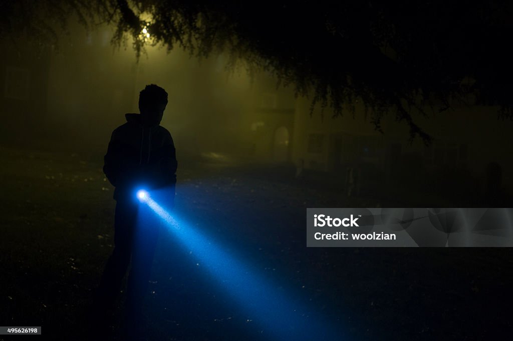 misty search hooded boy searched during a misty evening Flashlight Stock Photo